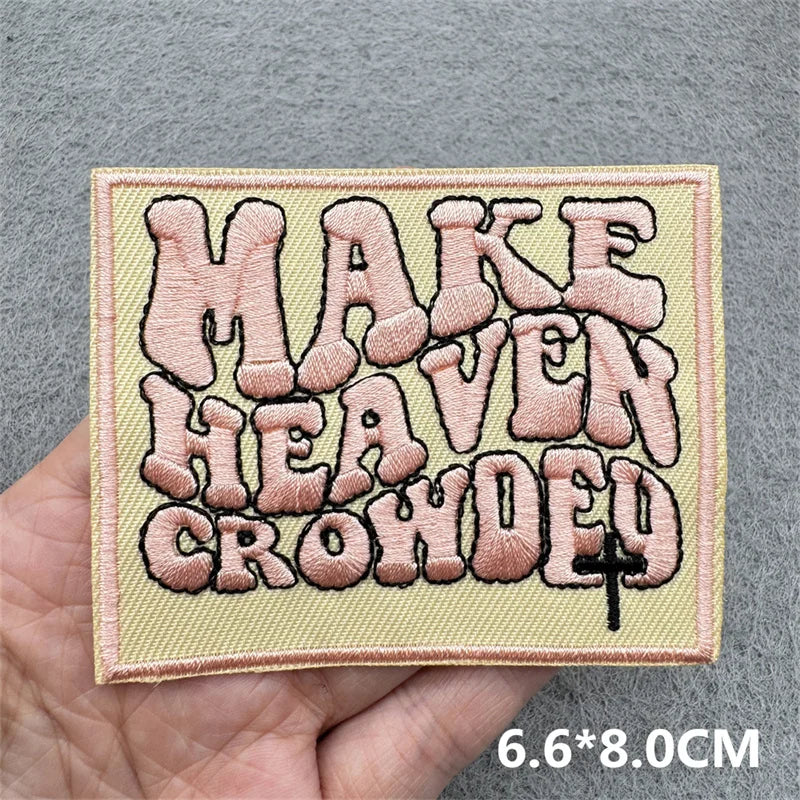 Embroidered patch with text held by a hand on a gray background