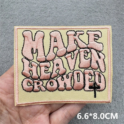 Embroidered patch with text held by a hand on a gray background