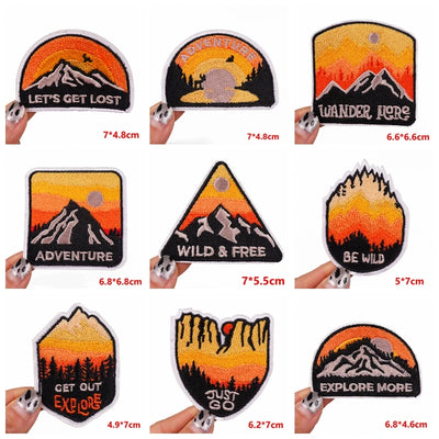Collection of motivational patches with scenic designs and text, held by hands for size reference.