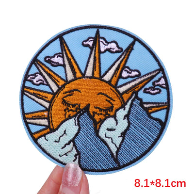 Circular patch with sun and mountain design held by a hand, with size '8.1*8.1cm' displayed.