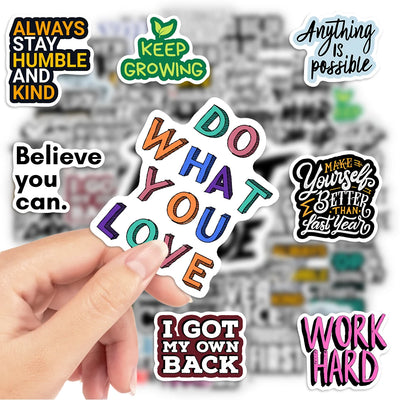Hand holding a colorful 'Do What You Love' sticker with other motivational stickers in the background.