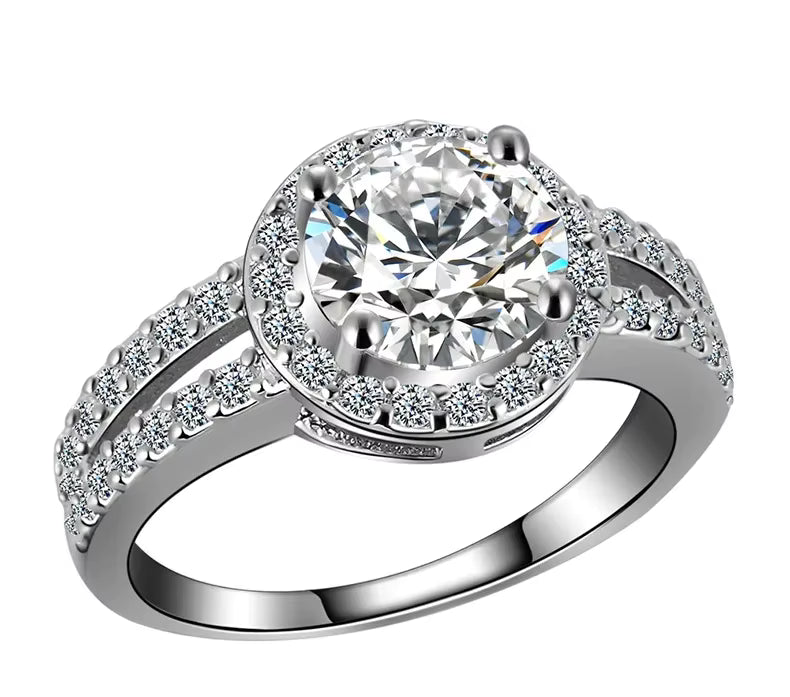 Silver ring with a large central crystal and smaller crystal on a white background