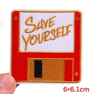Patch with 'Save Yourself' text on a red background, held by a hand.