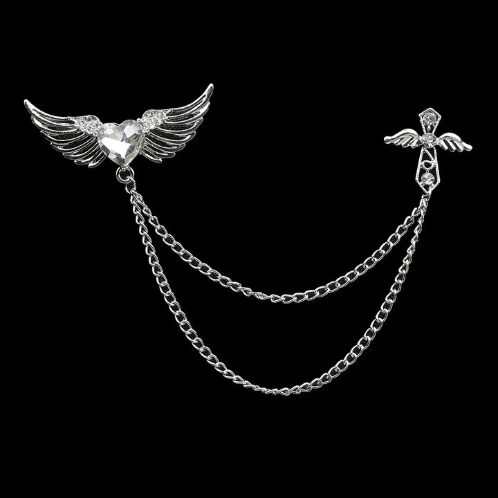 Silver brooch with wings and chain on a black background