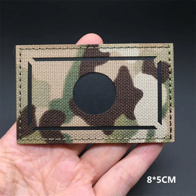 Japan flag Camouflage patch held in a hand against a dark background
