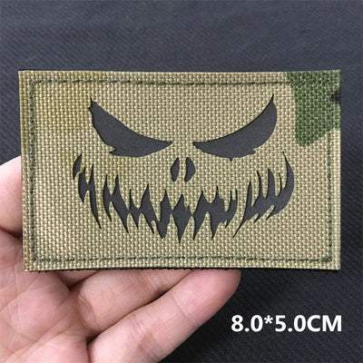 Tactical patch with skull design held by a hand on a dark background