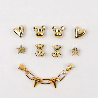 Set of gold earrings including heart, bear, and star designs on a white background.