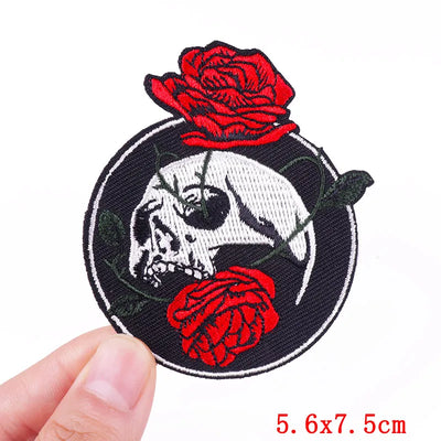 Patch with skull and red roses held by a hand on a white background