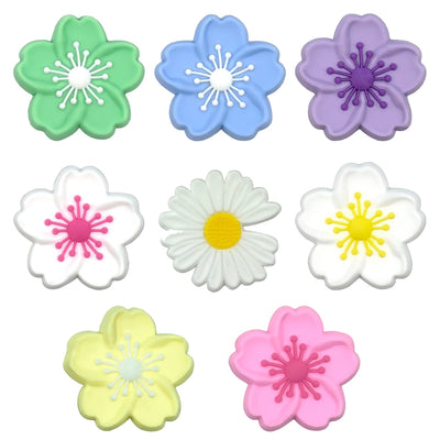 Set of colorful flower-shaped shoe charms on a white background