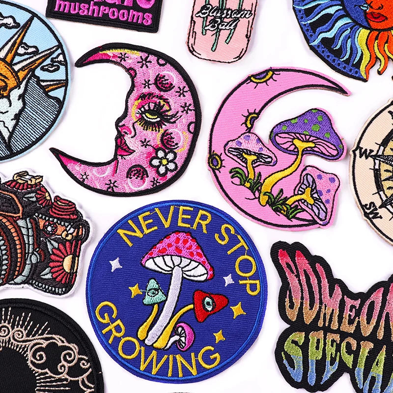 Collection of colorful patches with various designs including mushrooms and motivational text.