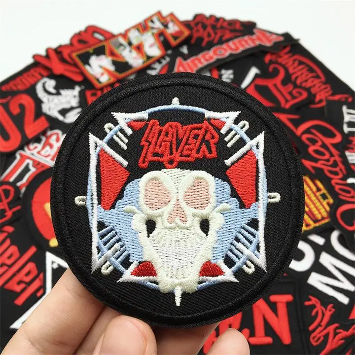 Slyder patch with skull design held over a collection of other patches.