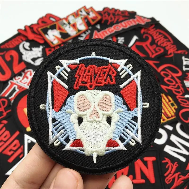Slyder patch with skull design held over a collection of other patches.