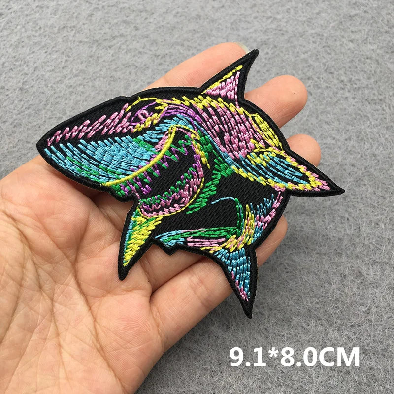 Colorful embroidered patch held in a hand with dimensions displayed