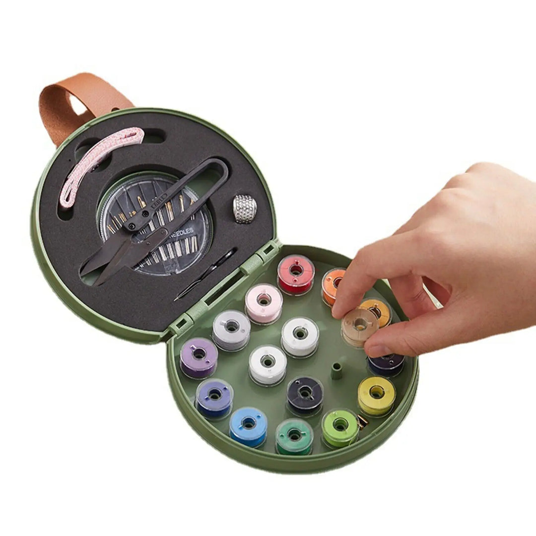 Round sewing kit with colorful thread spools and a hand interacting with it on a white background