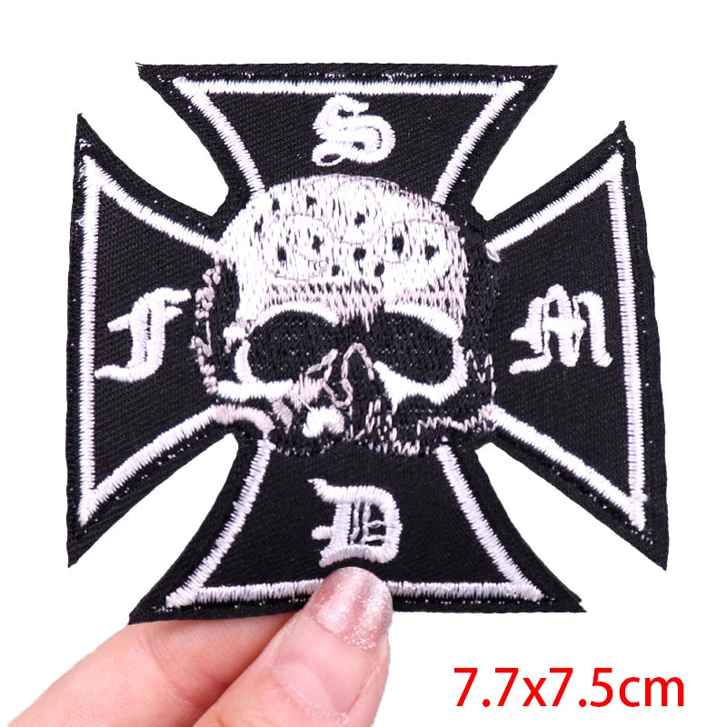 Black and white skull and crossbones patch held by a hand with size label '7.7x7.5cm'.