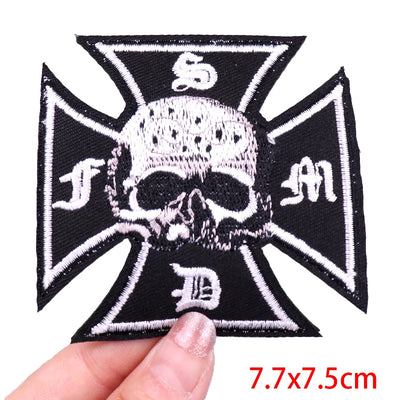 Black and white skull and crossbones patch held by a hand with size label '7.7x7.5cm'.