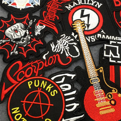 Collection of various patches with musical instruments, skulls, and text on a dark background