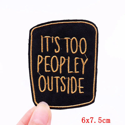 Embroidered patch with 'It's Too Peopley Outside' text held by a hand on a white background