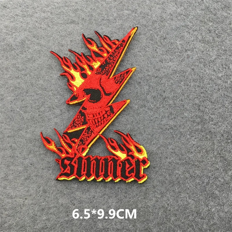 Red and black embroidered patch with flames on a gray background