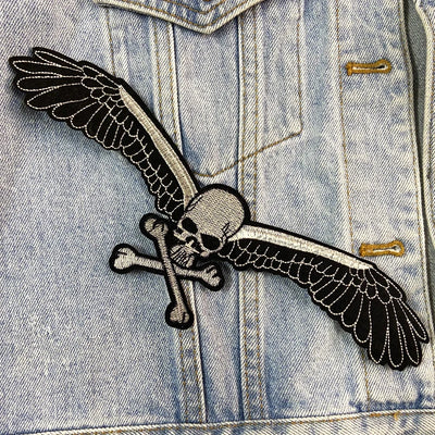 Denim jacket with a skull and wings patch