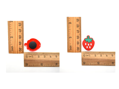 Wooden rulers with red and green shoe charms on a white background