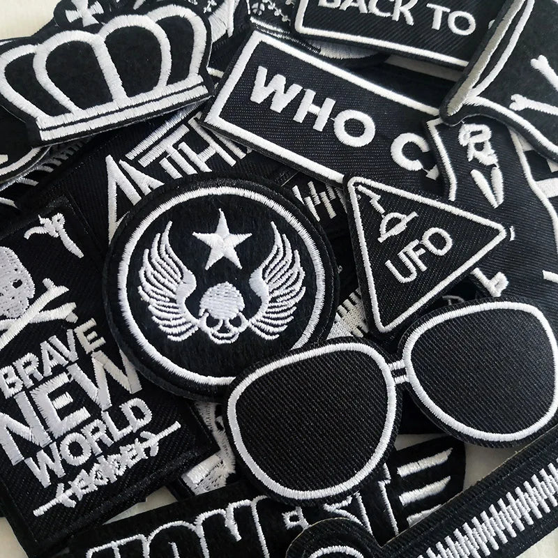 Collection of black and white patches with various designs and text.