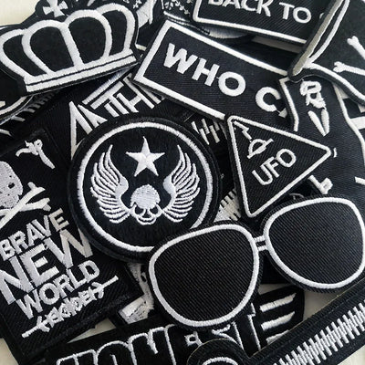 Collection of black and white patches with various designs and text.