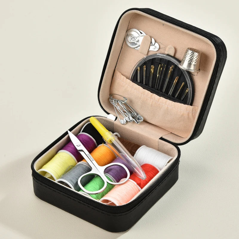Black Sewing kit with colorful threads, scissors, and other tools in a black case on a beige background