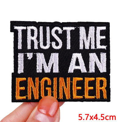 Embroidered patch with 'Trust Me I'm an Engineer' text held by a hand.