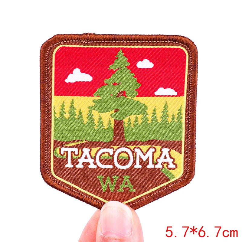 Patch with 'Tacoma WA' text and tree design held by a hand