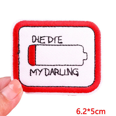 Embroidered patch with battery symbol and text 'DIE DTE MY DARLING' held by a hand, on a white background.