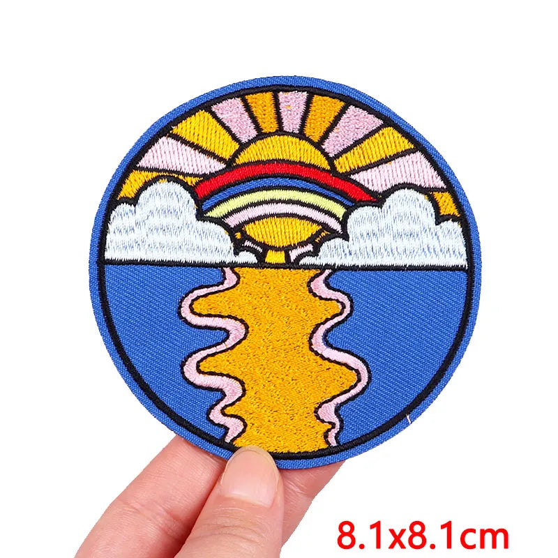 Circular patch with a sunset design held by a hand, size 8.1x8.1cm.