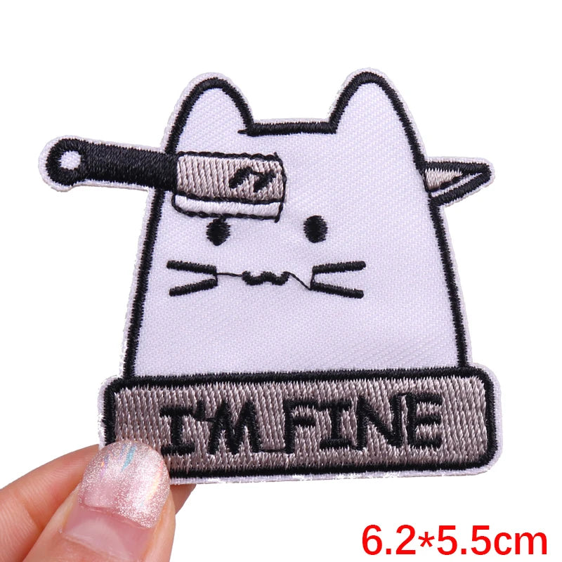Patch with a cat design and 'I'm Fine' text held by a hand on a white background