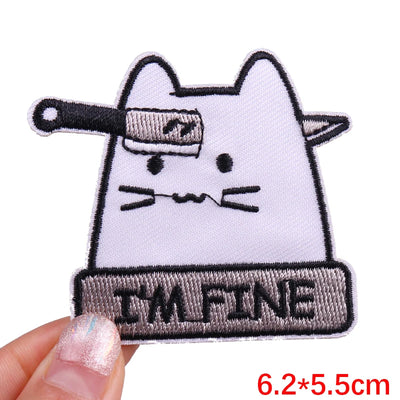 Patch with a cat design and 'I'm Fine' text held by a hand on a white background