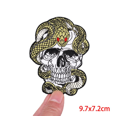 Skull with snake design held by a finger, with size '9.7x7.2cm' displayed.