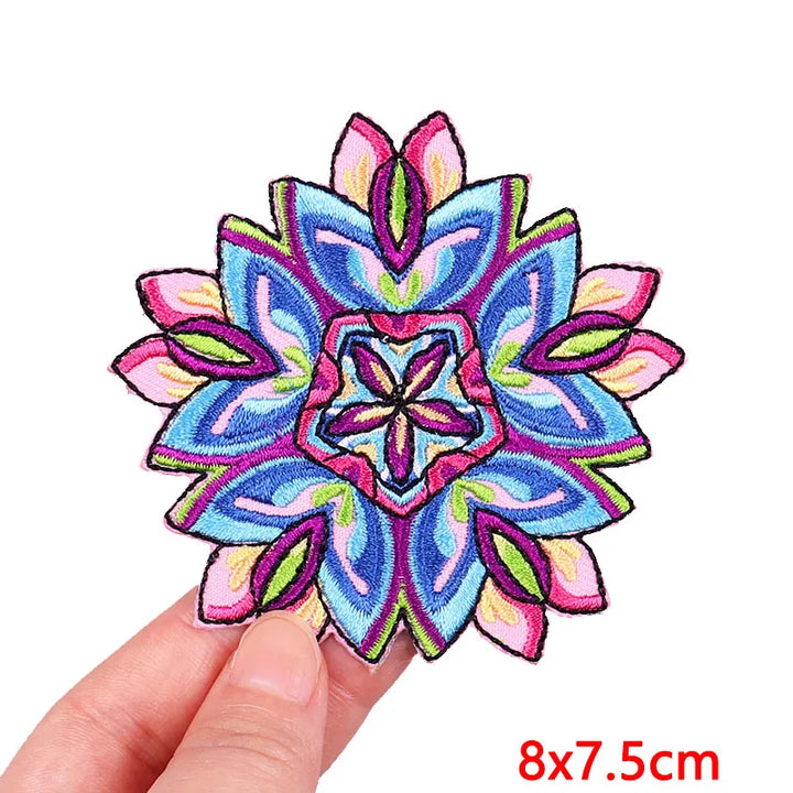 Colorful embroidered flower patch held by a hand with dimensions indicated.