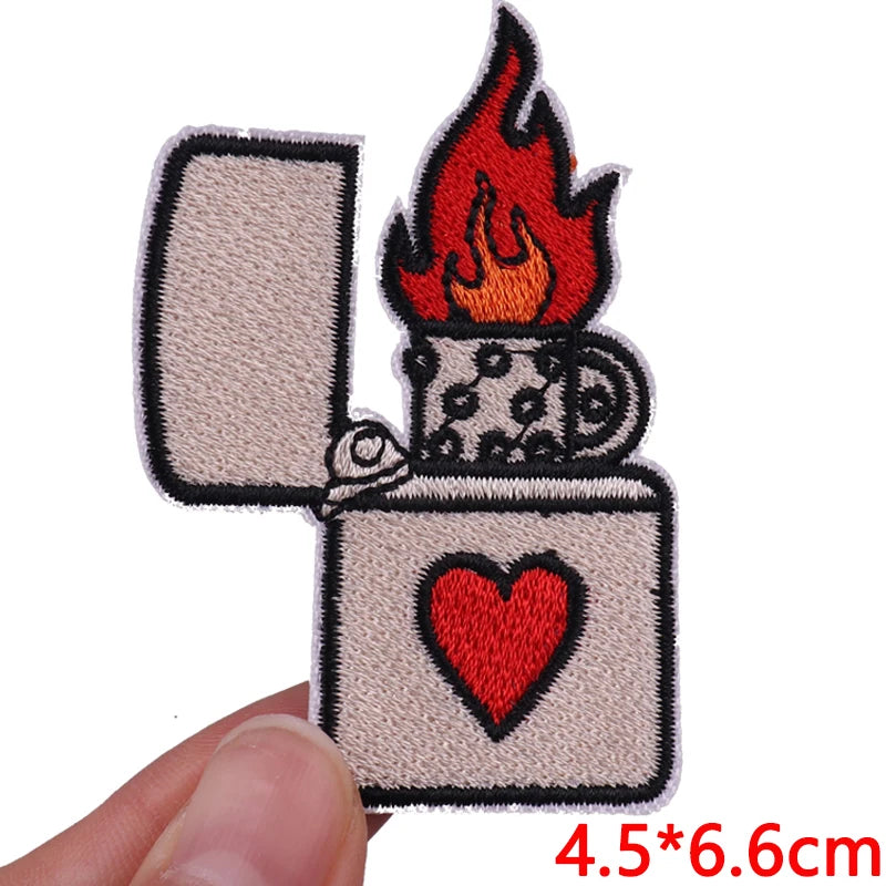 Embroidered patch of a lighter with flames and a heart on a white background