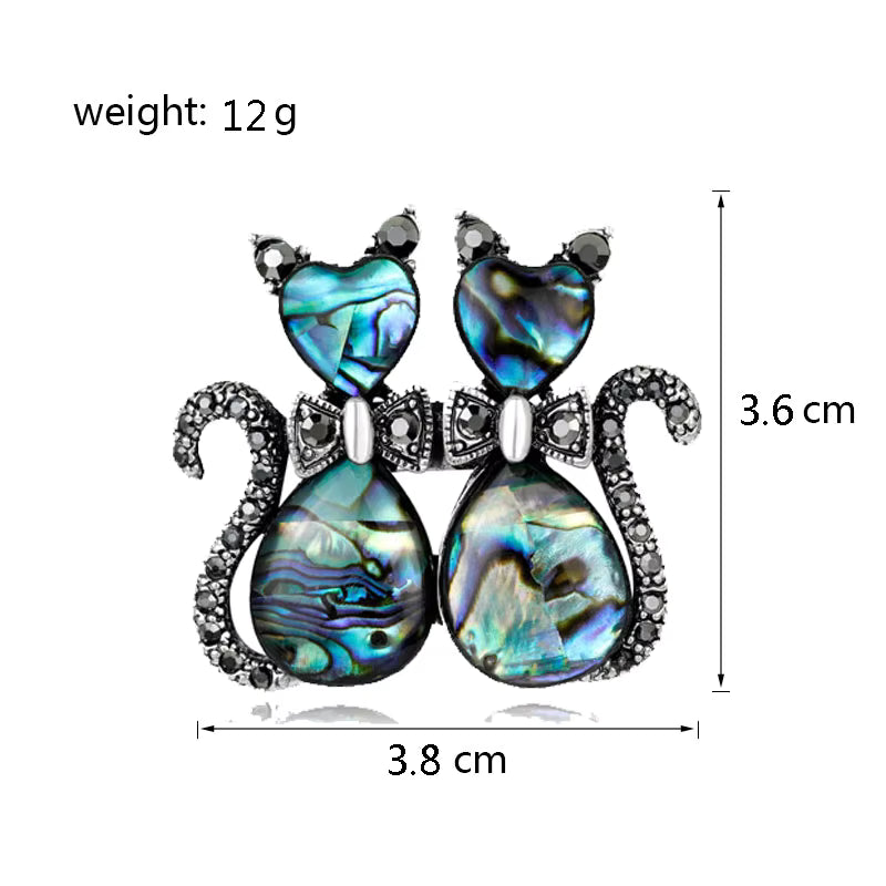Pair of cats  brooch with  gemstones and measurements on a white background