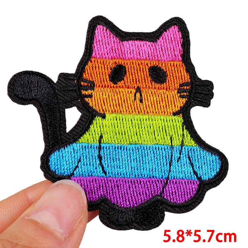 Colorful cat-shaped patch held by a hand with dimensions displayed.