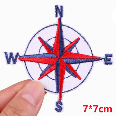 Compass rose patch held by a hand with dimensions indicated