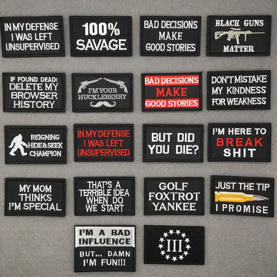 Collection of black patches with various text designs on a gray background