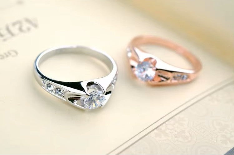 Two rings, one silver and one rose gold, on a light surface.