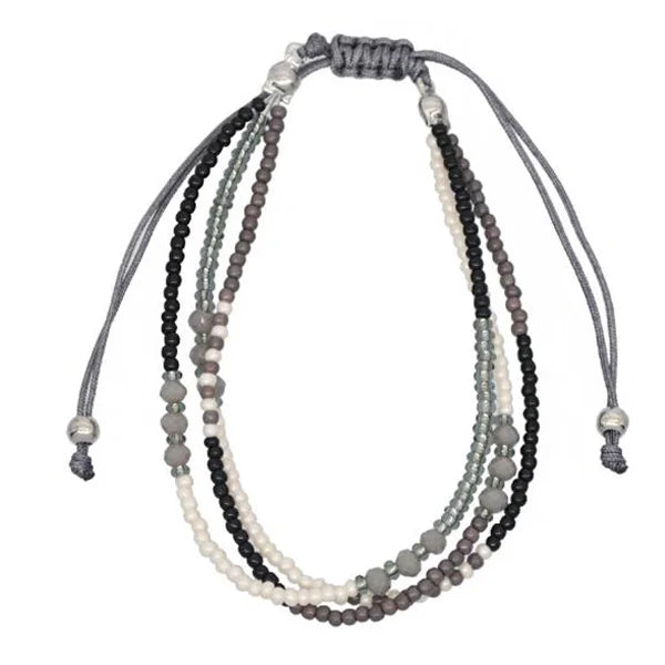 Multistrand beaded necklace with gray, black, and white beads on a white background
