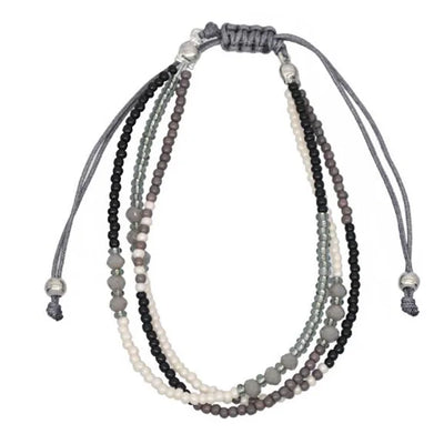 Multistrand beaded necklace with gray, black, and white beads on a white background