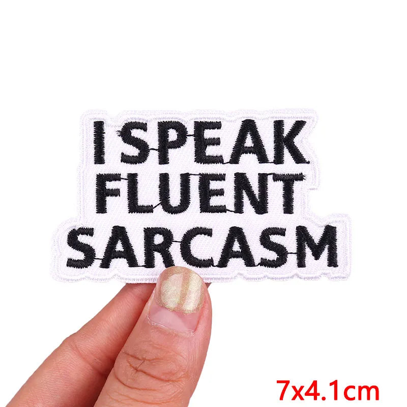 Patch with 'I Speak Fluent Sarcasm' text held by a hand on a white background