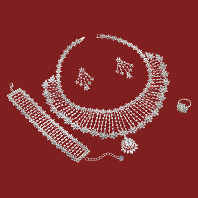 Silver jewelry set including necklace, bracelet, ring and earrings on a red background