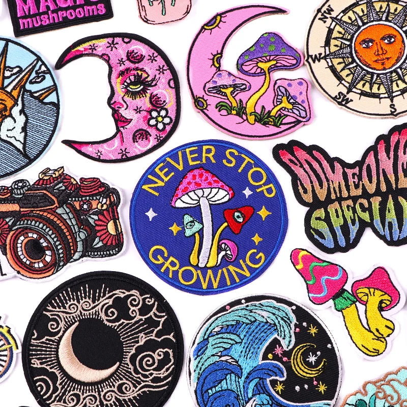 Collection of colorful patches with various designs including mushrooms, moons, and text.