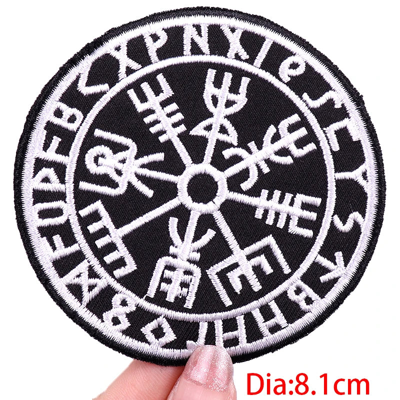 Circular patch with Runes design held by a hand, on a white background