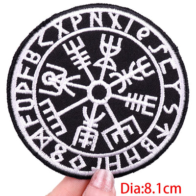 Circular patch with Runes design held by a hand, on a white background