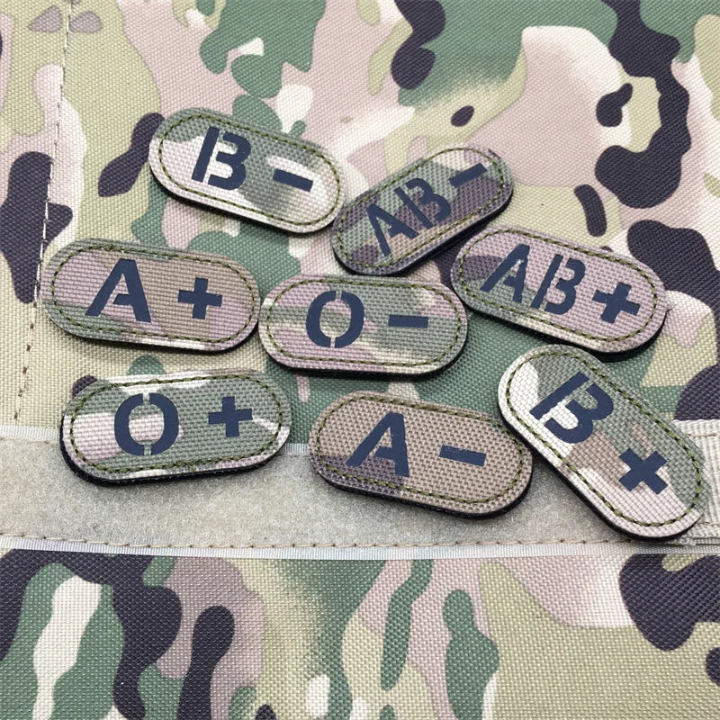 Set of multicam tactical blood type hook and loop patches with black lettering approximately 4.8x2.4cm on a camouflage background